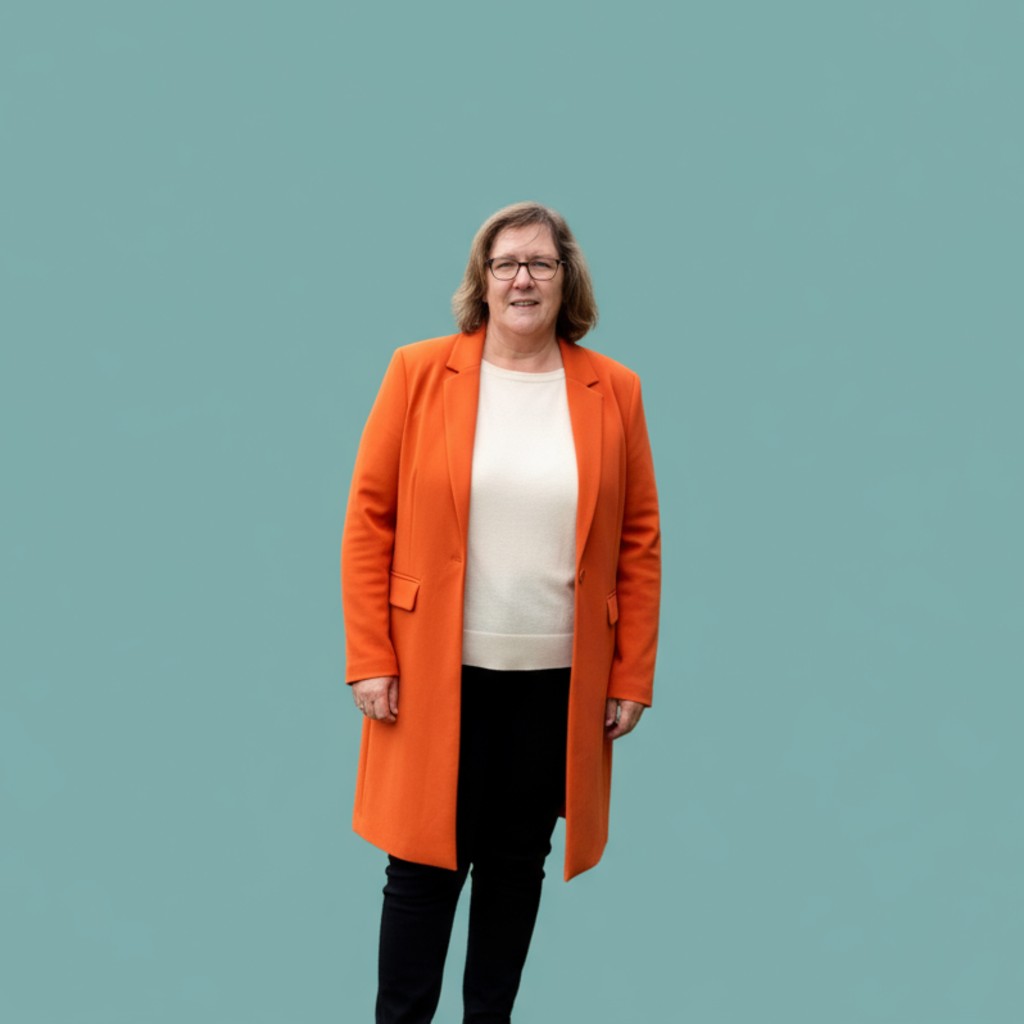 Nicola in an orange jacket with a teal background